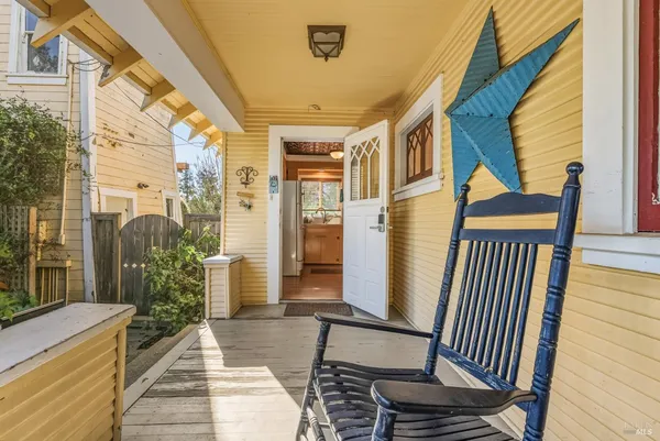 a view of a balcony with wooden floor and iron stairs