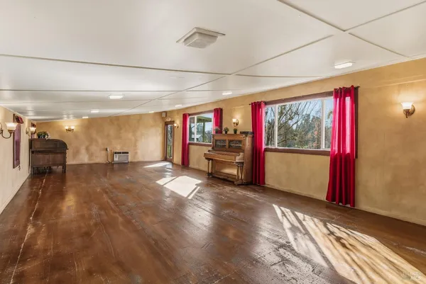 a view of an empty room with a fireplace and a window