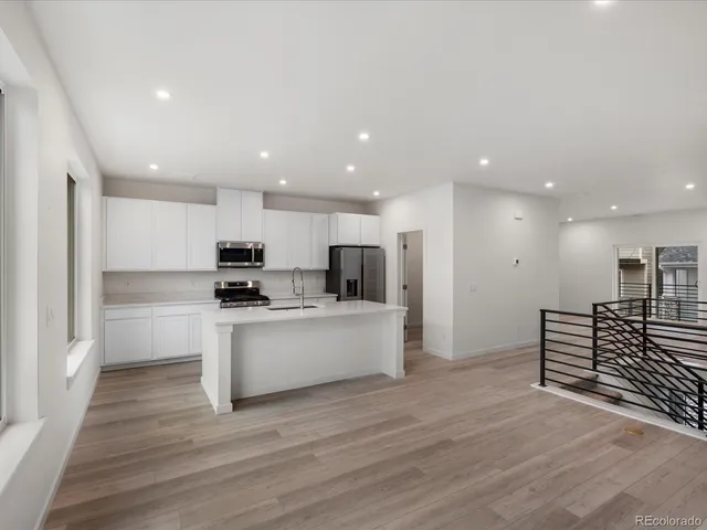 a view of kitchen with wooden floor and electronic appliances