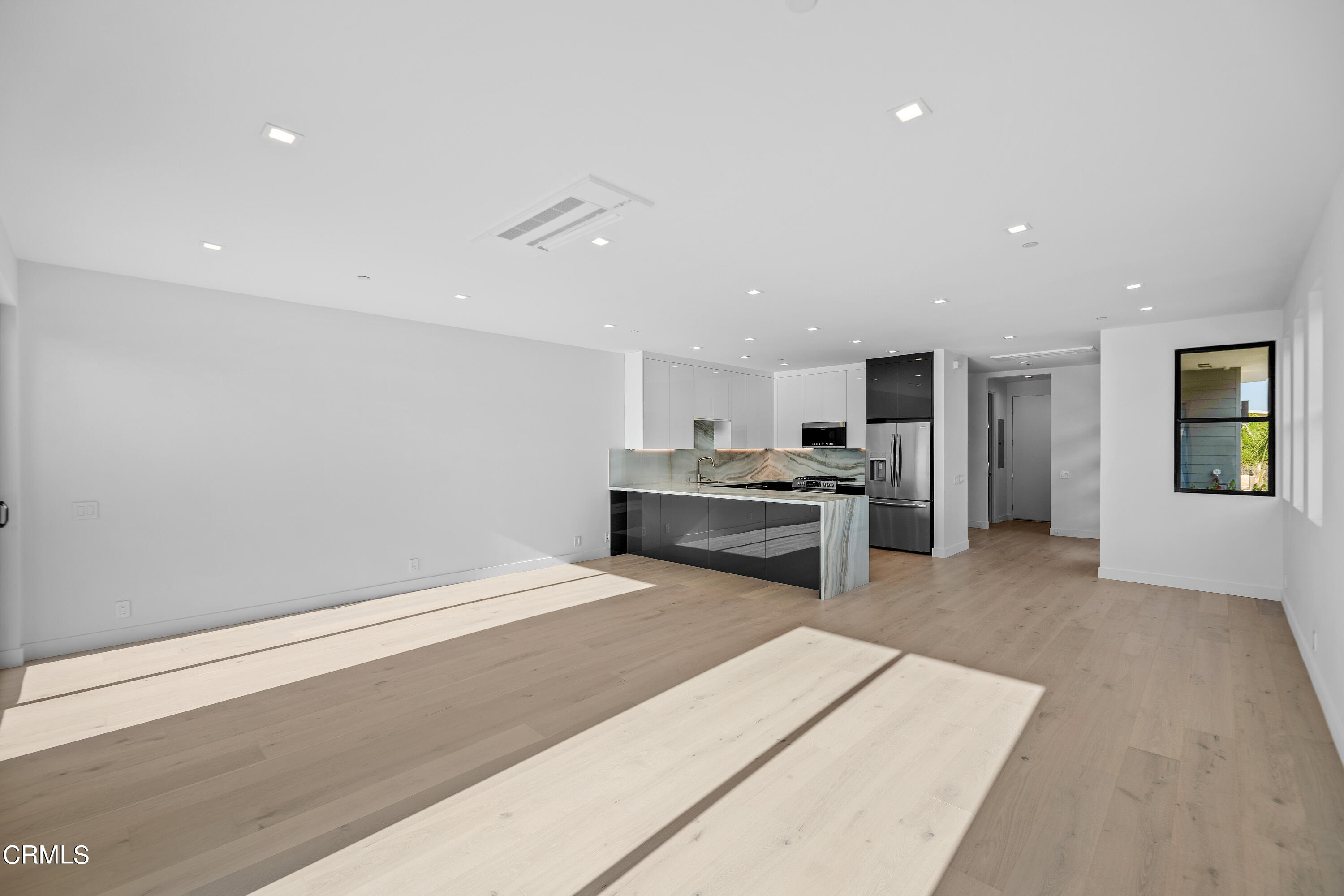 1005 Catamaran Street Oxnard, CA 93035 - Photo 21 of 35 a large white kitchen with a stove a sink dishwasher and a refrigerator with wooden floor