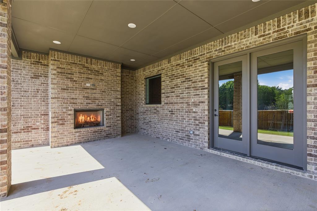 713 Anne Road Van Alstyne, TX 75495 - Photo 26 of 29 Covered outdoor patio featuring a built-in fireplace, brick construction, recessed lighting, and double glass doors