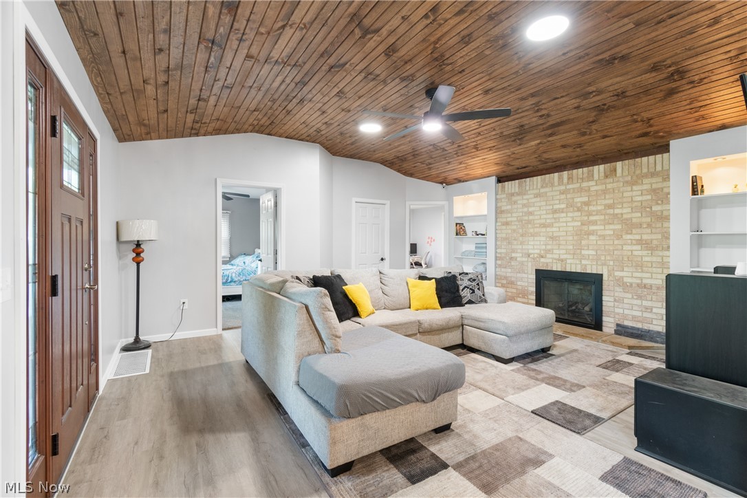3255 Old Weymouth Road Medina, OH 44256 - Photo 7 of 31 Living room with built in features, hardwood / wood-style floors, wood ceiling, and a brick fireplace