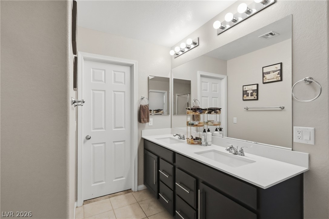 1921 Miller Ridge Avenue North Las Vegas, NV 89031 - Photo 21 of 26 This spacious bathroom offers a double vanity and ample mirror space for daily routines.