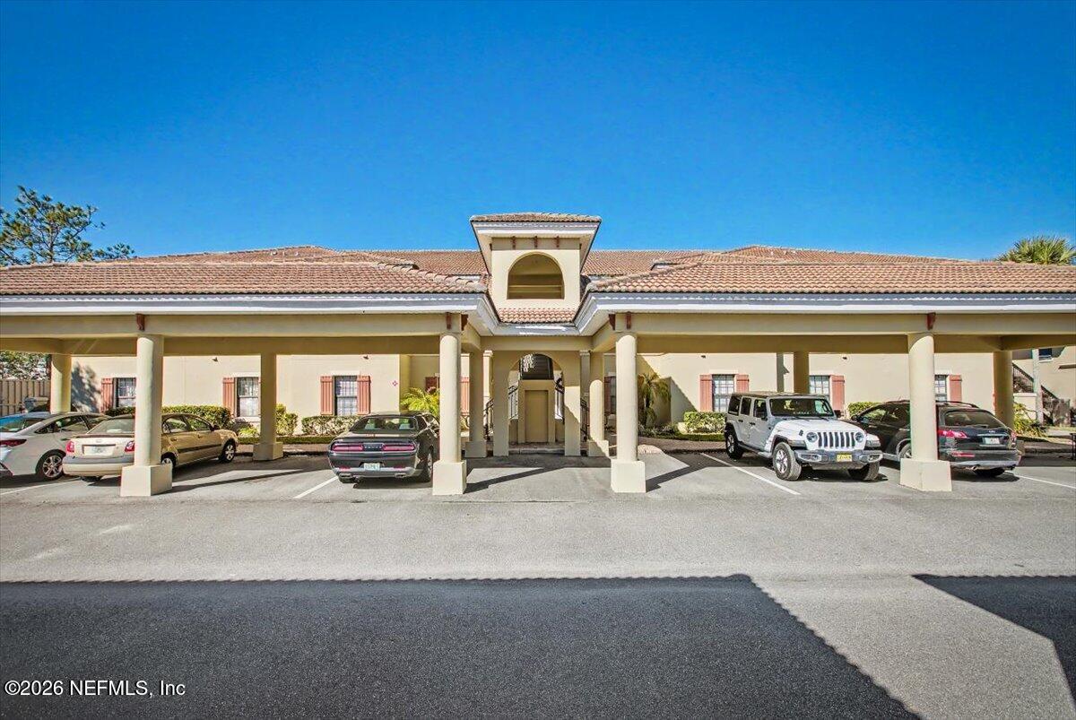 a view of a building with car parked in front of it