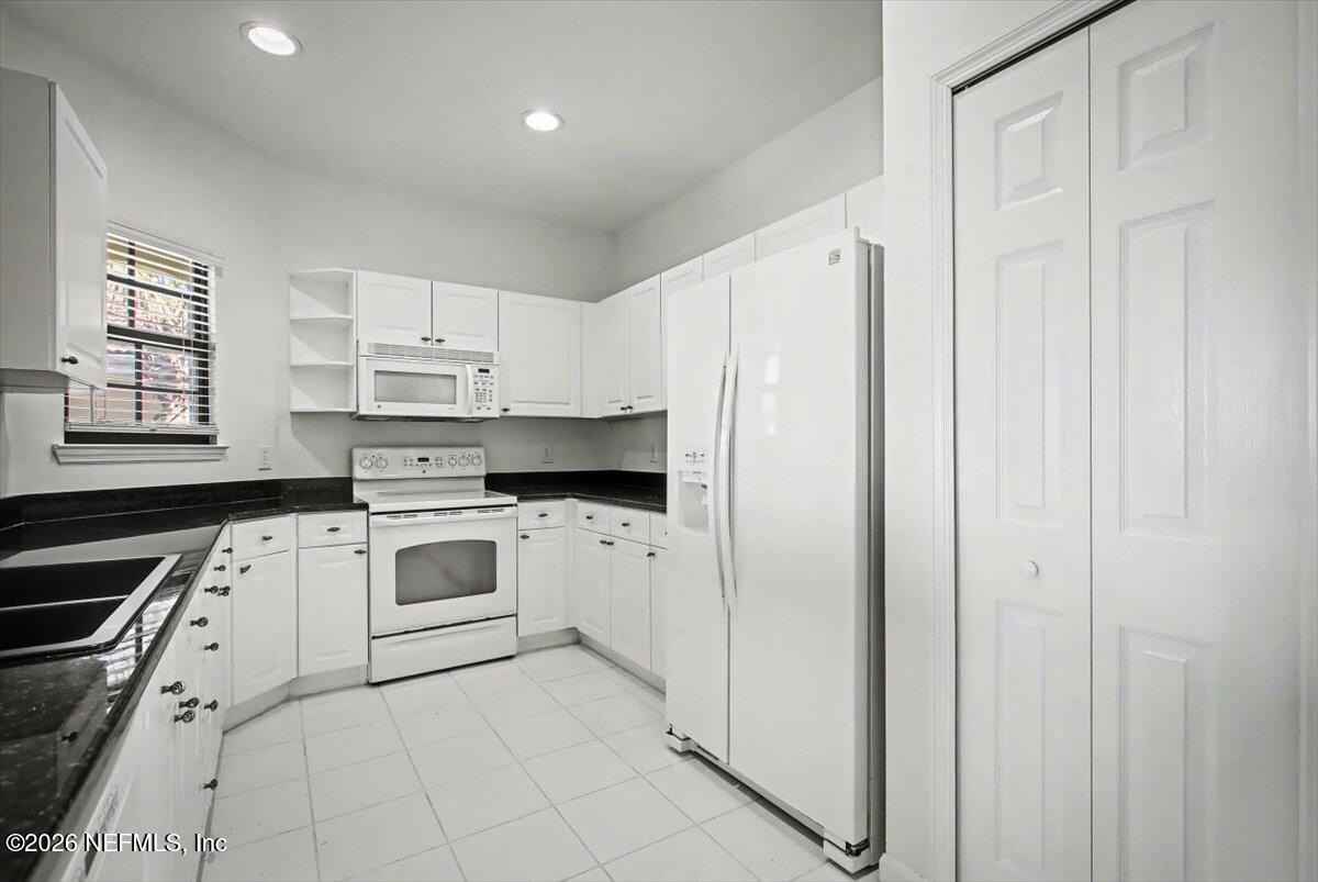 315 Via Castilla, Unit 204 St. Augustine, FL 32095 - Photo 5 of 18 a kitchen with white cabinets and white appliances