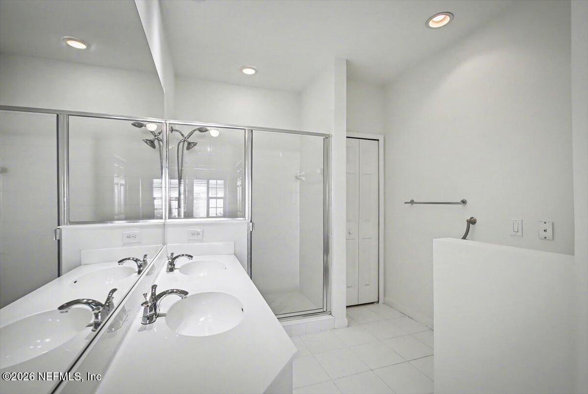 315 Via Castilla, Unit 204 St. Augustine, FL 32095 - Photo 9 of 18 a bathroom with a sink vanity granite tub shower and a mirror