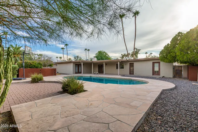a view of a house with pool fire pit and a yard