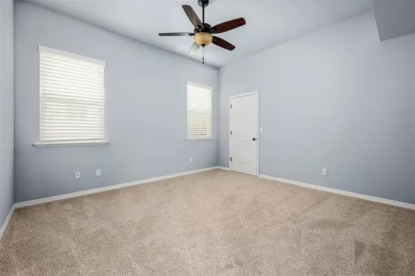 an empty room with a window and a fan