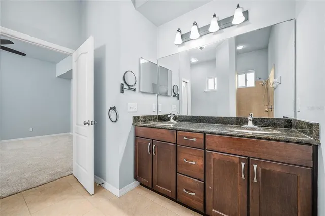 a bathroom with a granite countertop sink and a mirror
