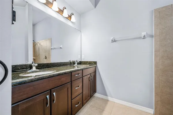 a bathroom with a granite countertop sink and a mirror