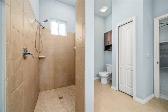 an empty room with a window and a ceiling fan