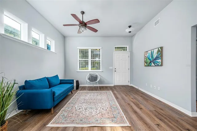 a living room with furniture and a wooden floor