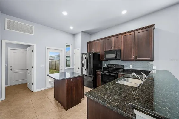 a kitchen with stainless steel appliances granite countertop a refrigerator stove and oven
