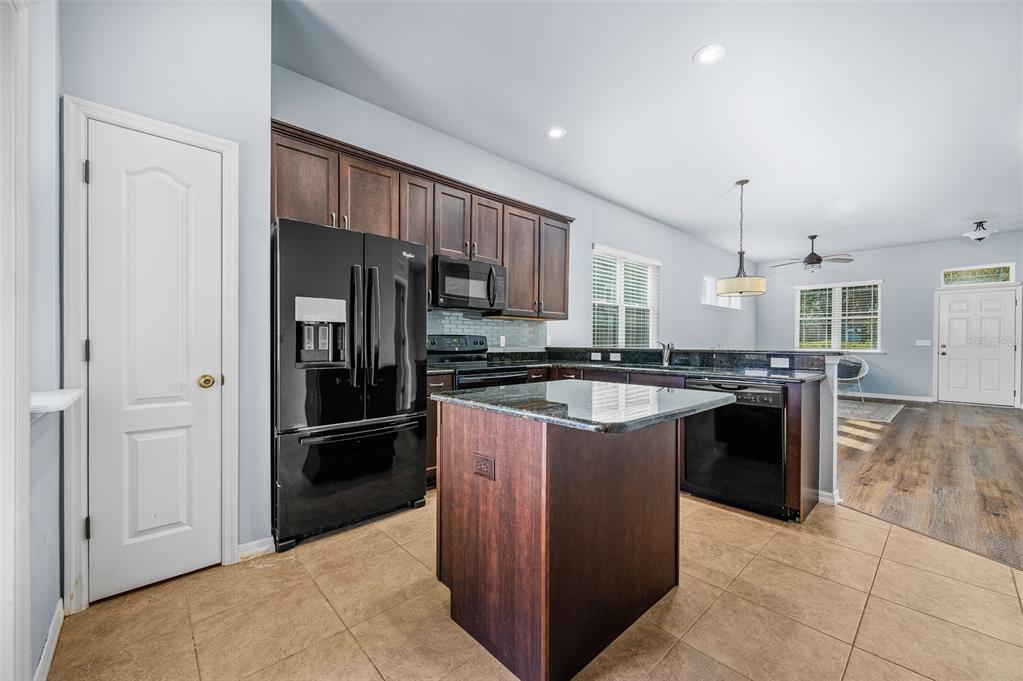 7891 Southwest 82nd Drive Gainesville, FL 32608 - Photo 9 of 38 a kitchen with stainless steel appliances granite countertop a refrigerator and a sink