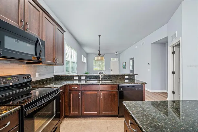 a kitchen with kitchen island a dining table chairs and a chandelier