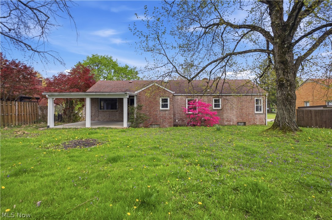 3232 Bears Den Road Youngstown, OH 44511 - Photo 33 of 38 Expansive backyard featuring a brick exterior, covered patio, mature tree, and vibrant pink flowering shrub