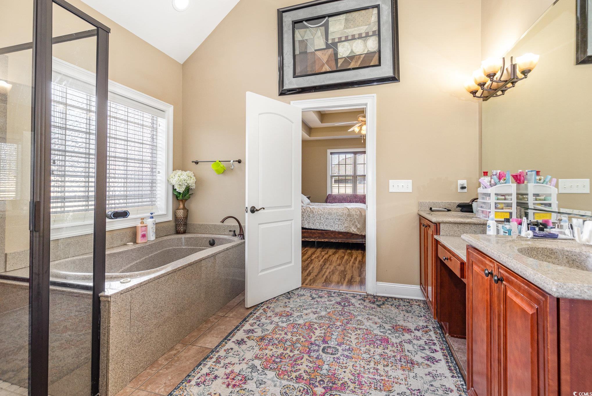1069 Cole Court Myrtle Beach, SC 29577 - Photo 20 of 40 Ensuite bathroom featuring vanity, a bath, lofted ceiling, light tile patterned floors, and a shower stall