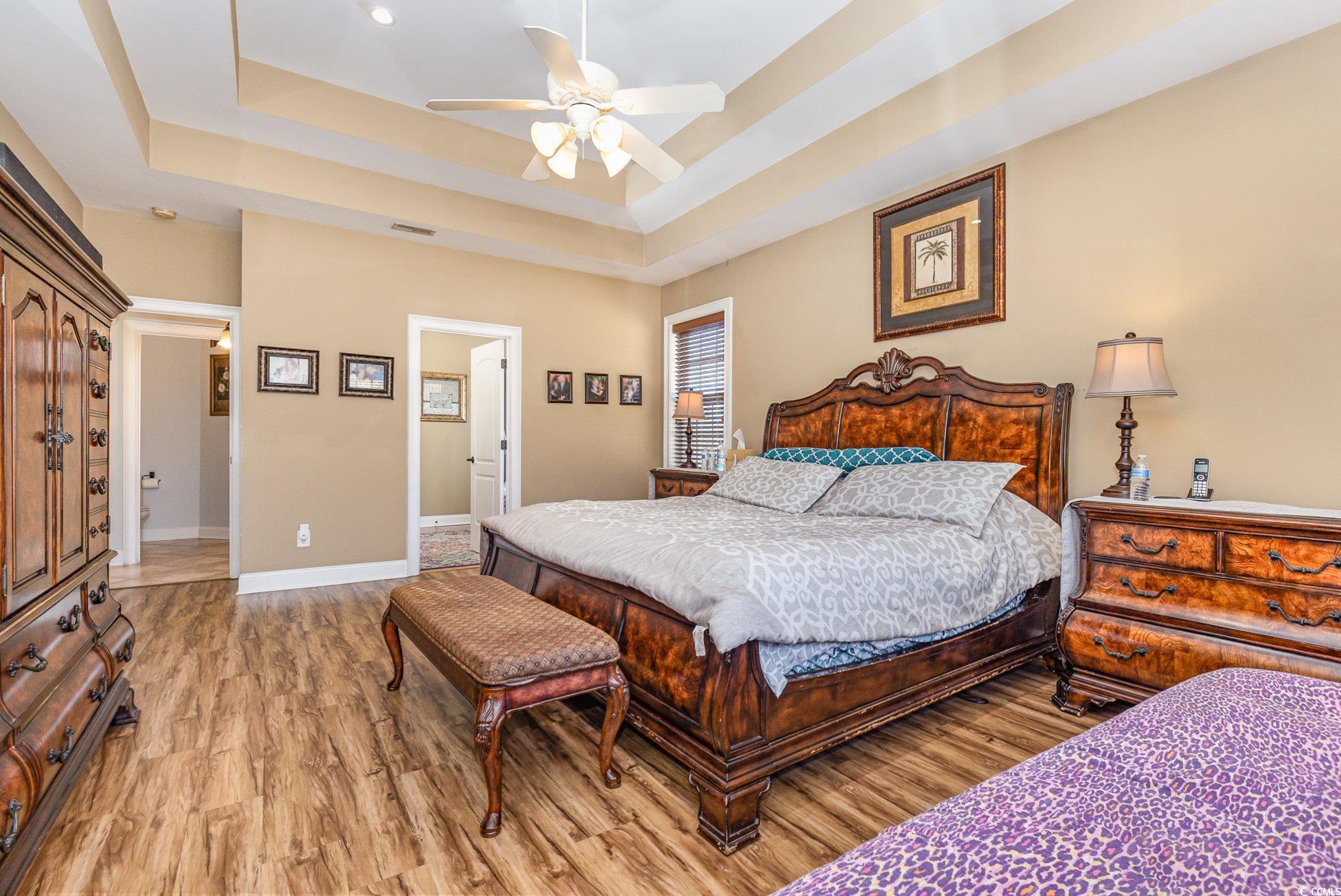 1069 Cole Court Myrtle Beach, SC 29577 - Photo 21 of 40 Bedroom featuring a tray ceiling, a ceiling fan, and light wood-style floors