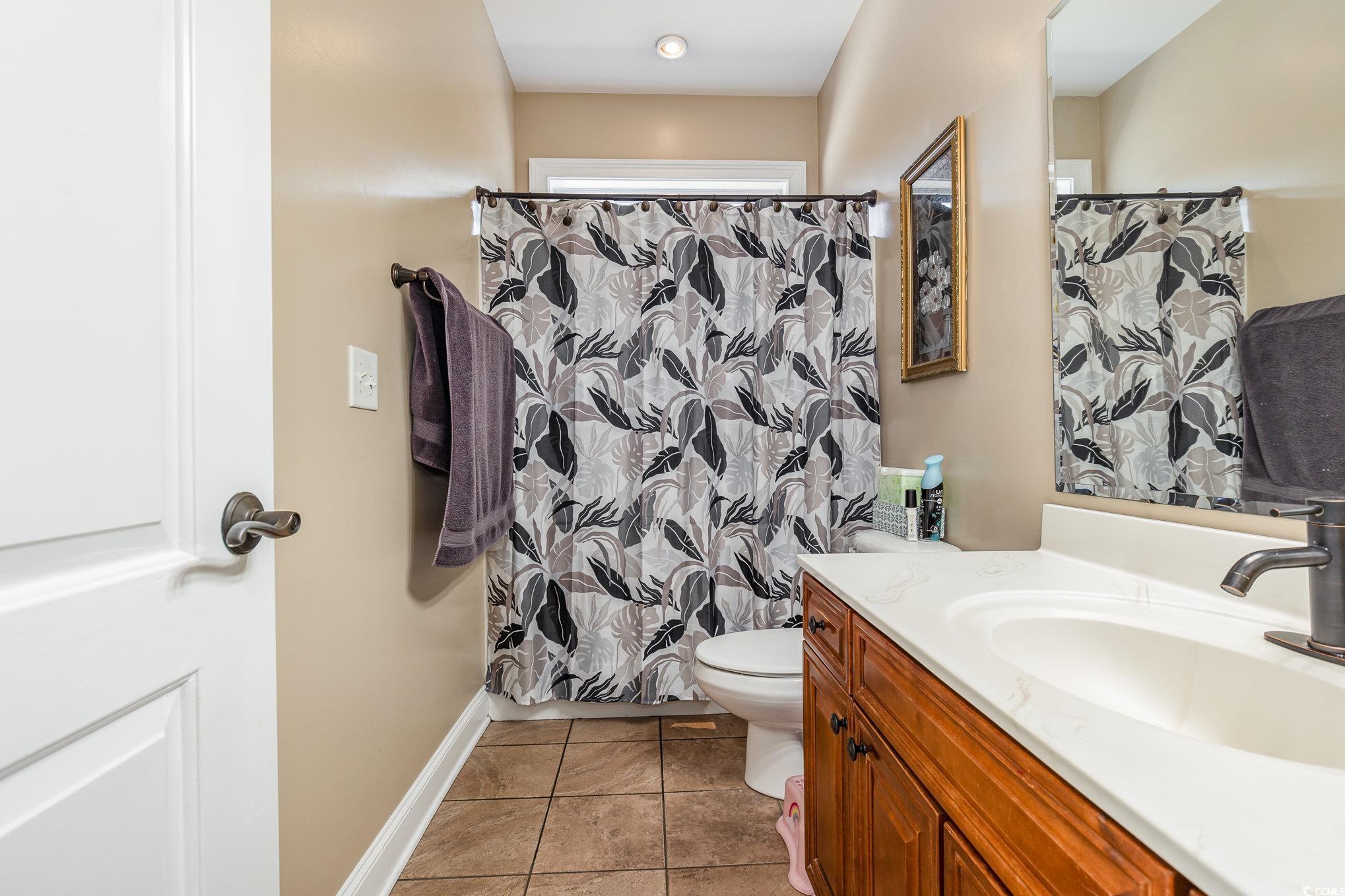 1069 Cole Court Myrtle Beach, SC 29577 - Photo 25 of 40 Full bathroom featuring a shower with shower curtain, vanity, and light tile patterned flooring