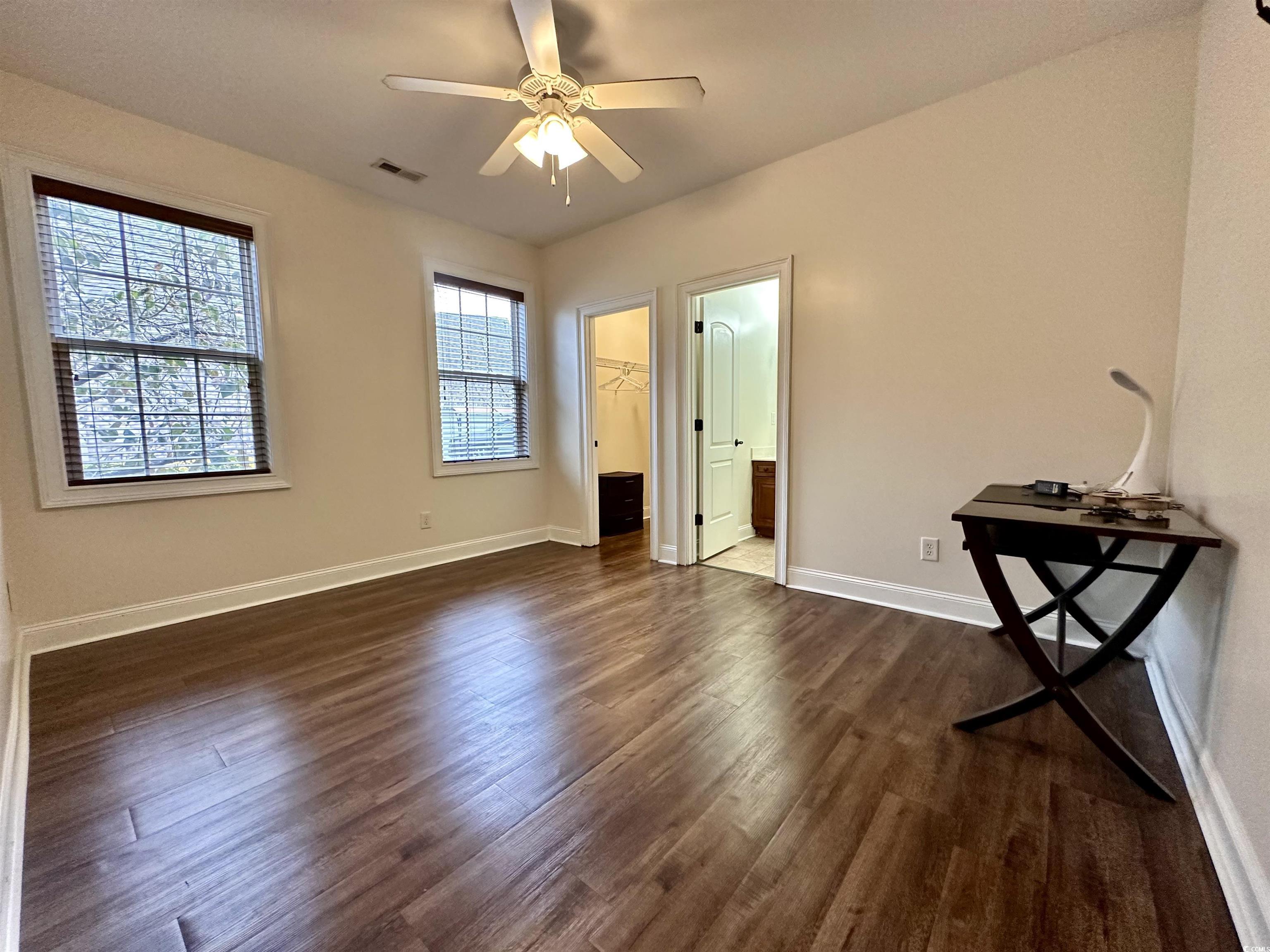 1069 Cole Court Myrtle Beach, SC 29577 - Photo 26 of 40 Unfurnished bedroom with dark wood-type flooring, a walk in closet, a ceiling fan, and ensuite bath