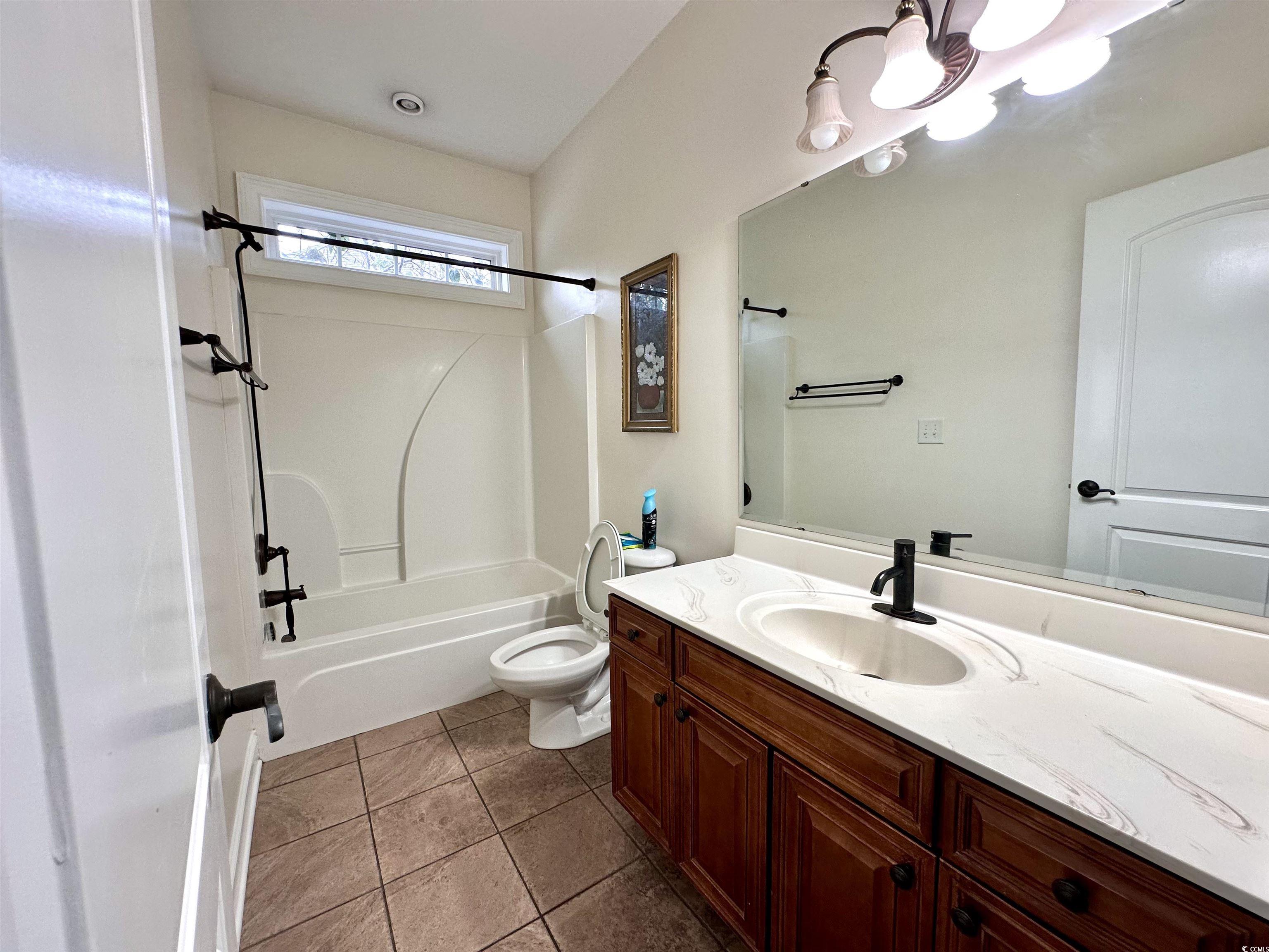 1069 Cole Court Myrtle Beach, SC 29577 - Photo 29 of 40 Full bathroom with shower / bath combination, vanity, and dark tile patterned floors