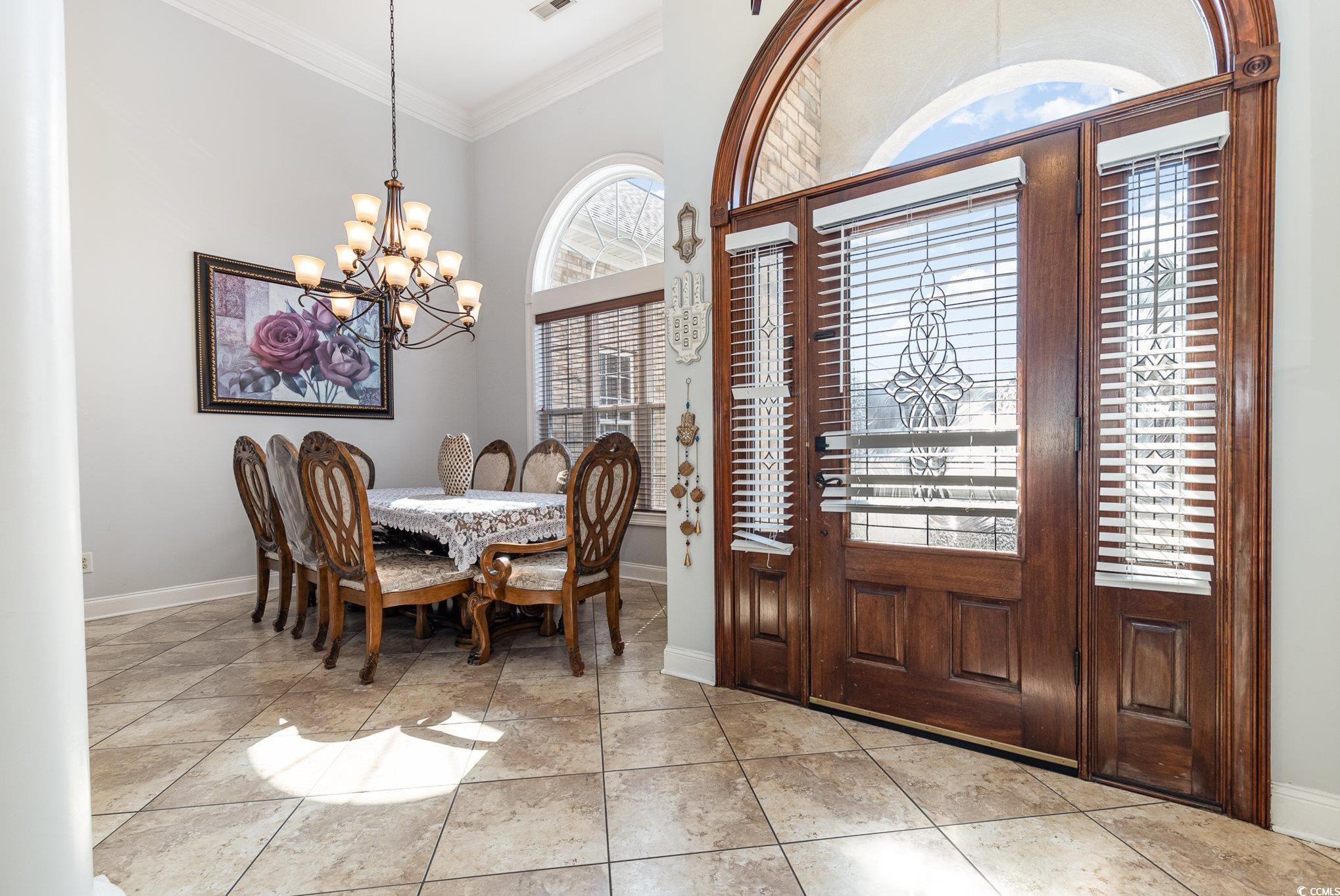 1069 Cole Court Myrtle Beach, SC 29577 - Photo 3 of 40 Foyer with crown molding, light tile patterned floors, and a chandelier