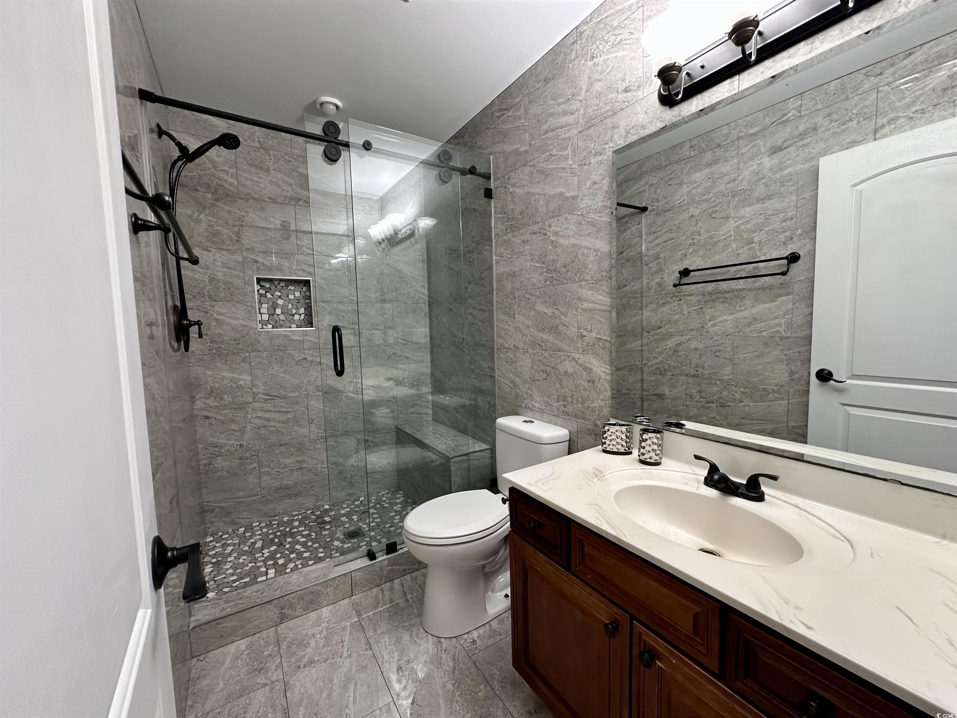 1069 Cole Court Myrtle Beach, SC 29577 - Photo 32 of 40 Full bathroom featuring tile walls, vanity, and a stall shower