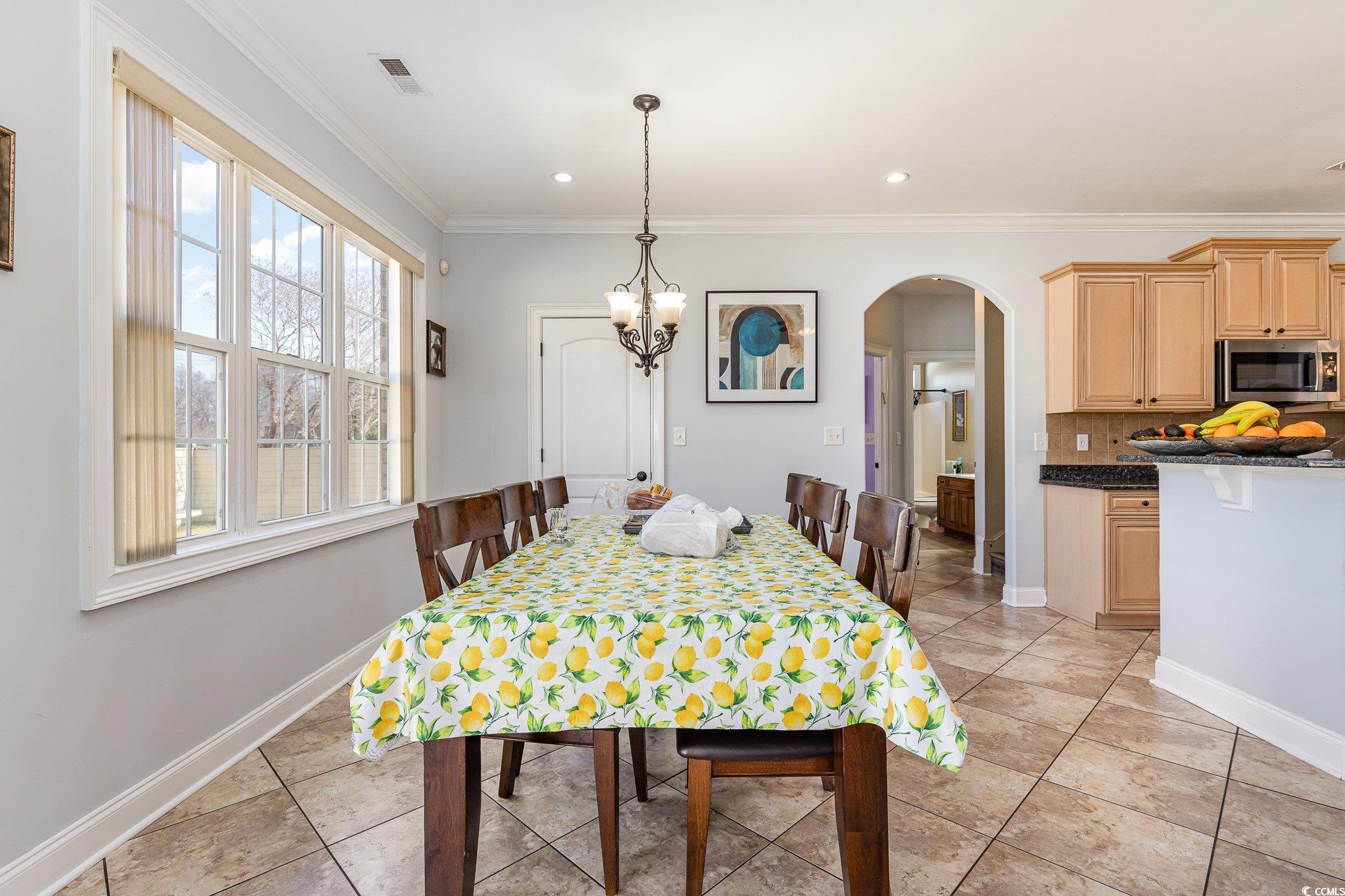 1069 Cole Court Myrtle Beach, SC 29577 - Photo 9 of 40 Dining room with arched walkways, crown molding, light tile patterned flooring, recessed lighting, and a chandelier