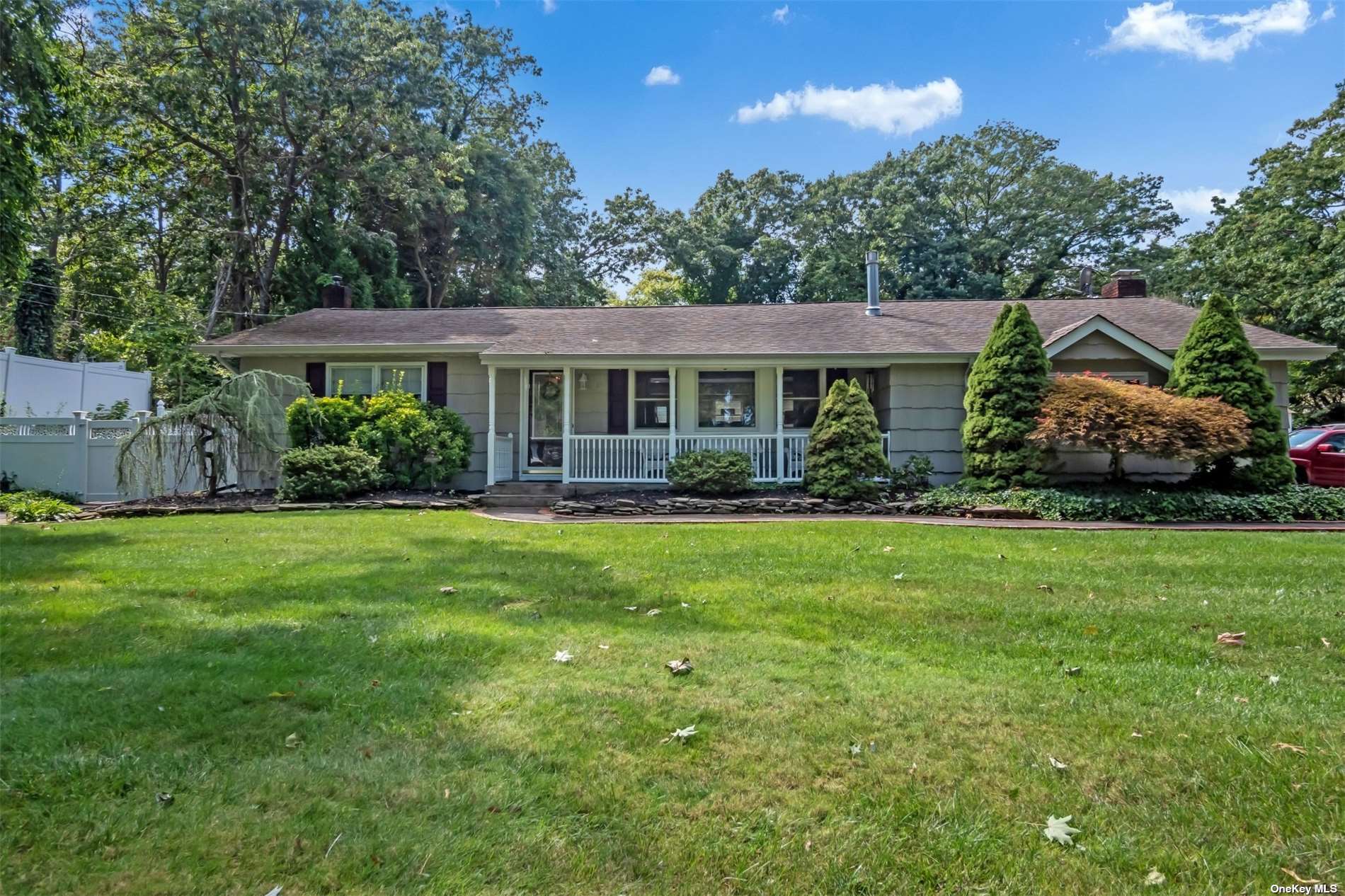 a front view of a house with a yard and potted plants
