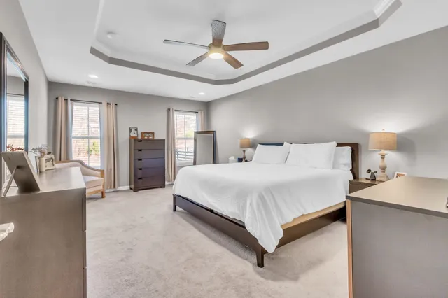 a spacious bedroom with a bed and ceiling fan