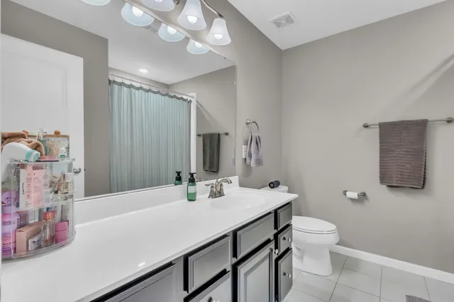 a bathroom with a sink vanity granite and toilet