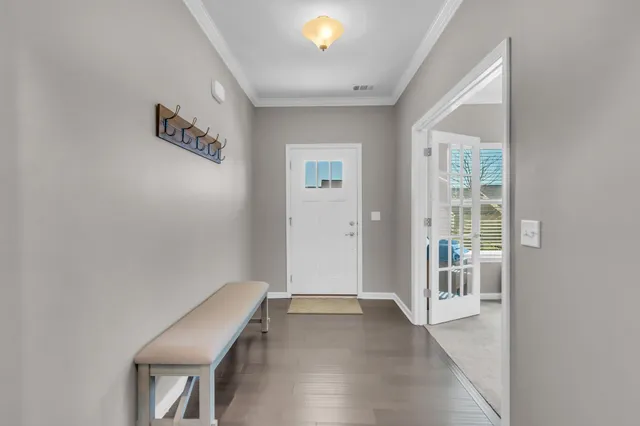 a view of a hallway with wooden floor and a bathroom