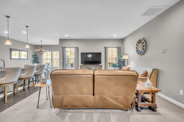 a living room with furniture a flat screen tv and kitchen view