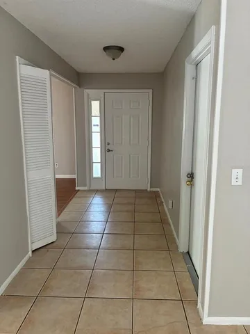 a view of hallway with a window and a red door