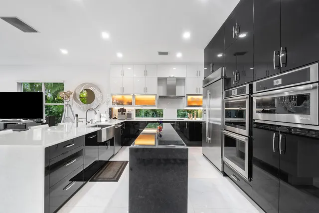 a kitchen with stainless steel appliances kitchen island granite countertop a stove and a sink