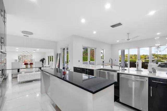 a large kitchen with a counter top space a sink a stove and cabinets