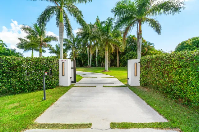 a view of swimming pool with a garden and palm trees
