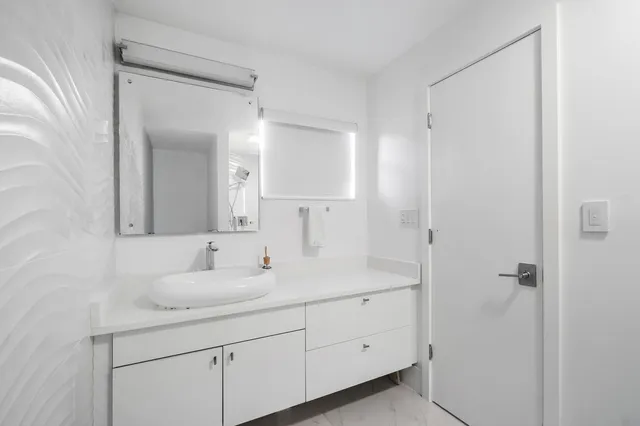 a bedroom with a bed and large windows