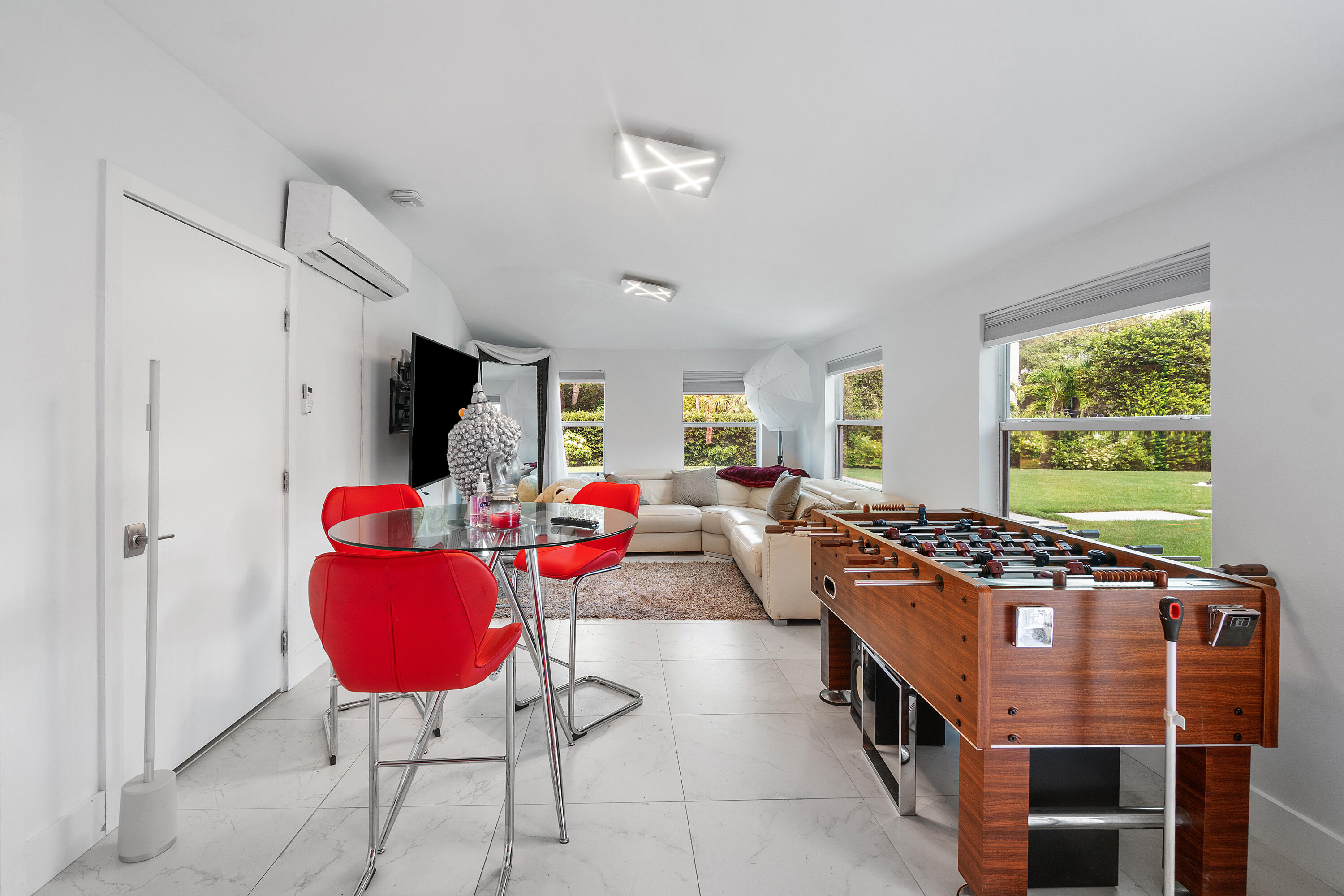 5447 Center Street Jupiter, FL 33458 - Photo 47 of 60 a living room with furniture flat screen tv and a large window