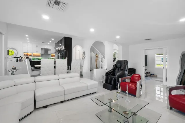 a living room with furniture and a chandelier