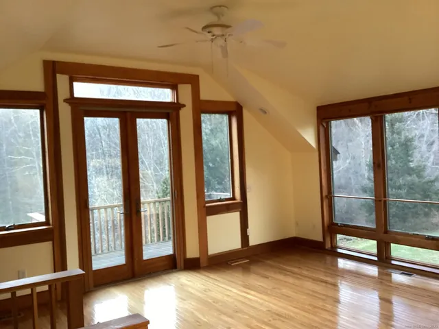 a view of a big room with wooden floor and windows