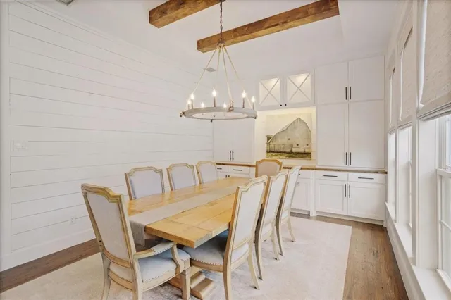 a dining room with furniture a chandelier and window