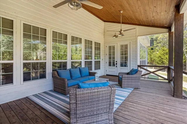a view of a balcony with furniture and large windows