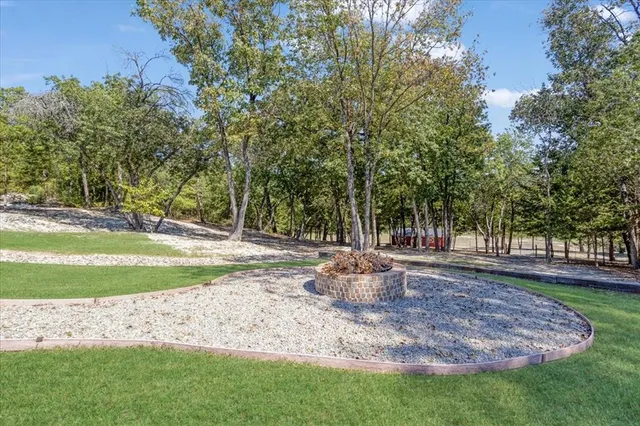 a view of a big house with a big yard and large trees