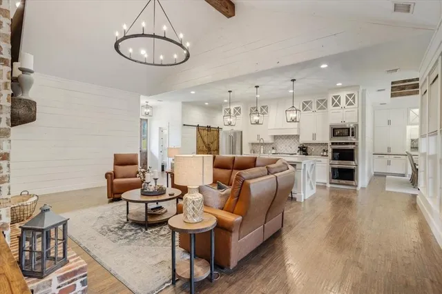 a living room with furniture kitchen and a large window