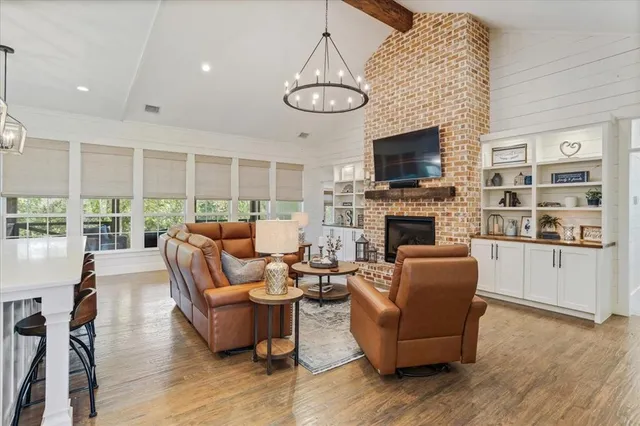 a living room with furniture kitchen view and a wooden floor