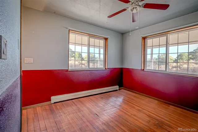 a big room with wooden floor and windows