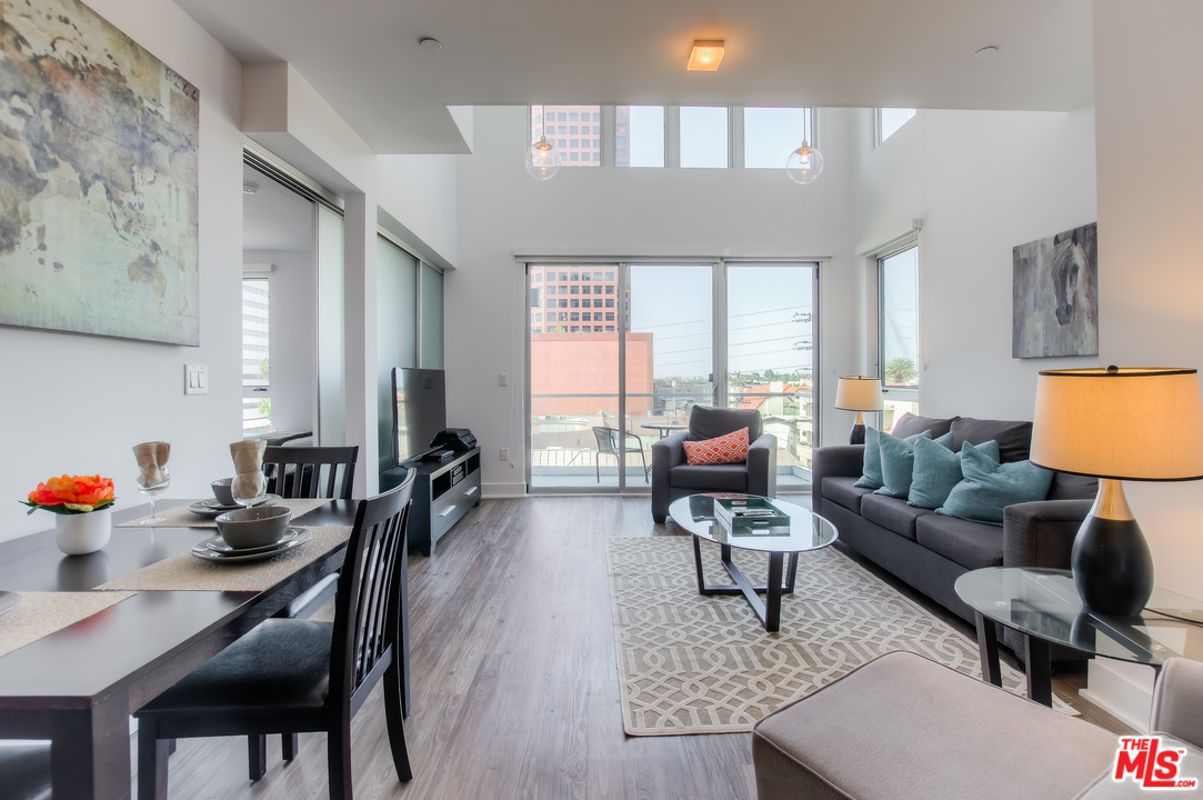 a living room with furniture and floor to ceiling windows