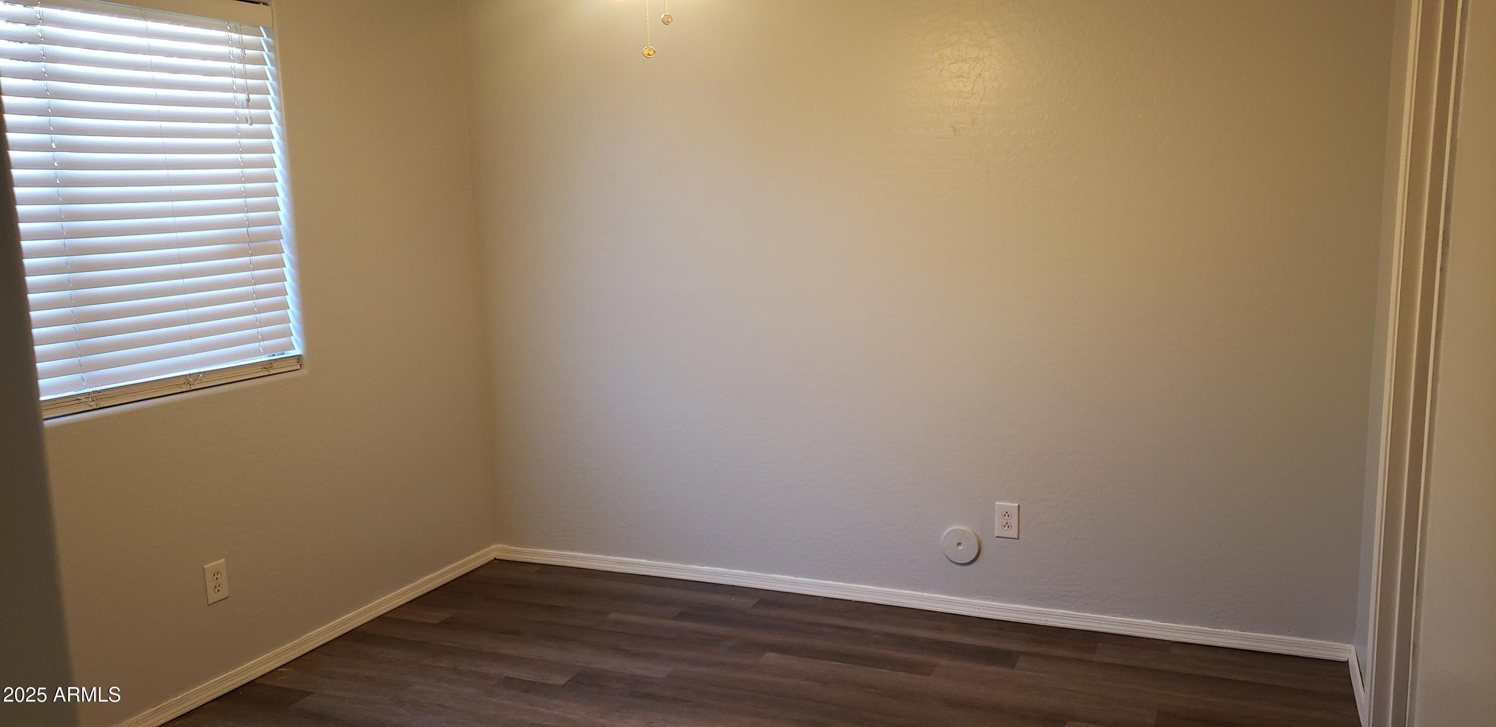 4631 West Shumway Farm Road Laveen, AZ 85339 - Photo 11 of 16 a view of an empty room with wooden floor and a window