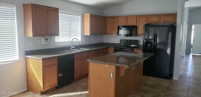 a kitchen with a sink a stove a refrigerator and cabinets